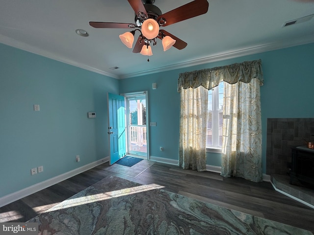 interior space featuring dark hardwood / wood-style flooring, a wood stove, ceiling fan, and crown molding