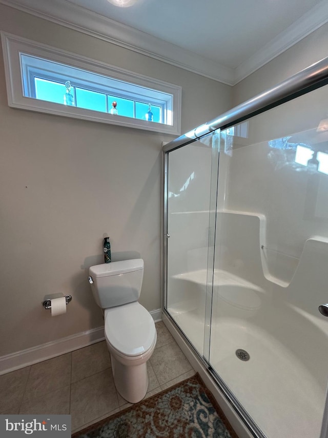 bathroom with tile patterned flooring, toilet, a shower with shower door, and ornamental molding