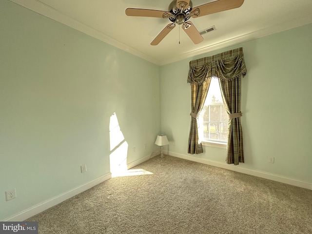 carpeted spare room with ceiling fan and ornamental molding