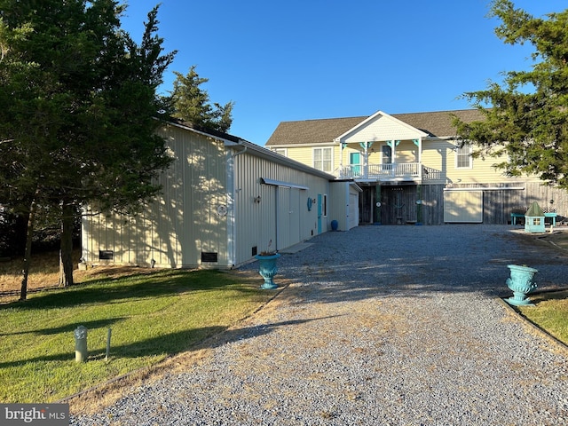 view of front facade featuring a balcony and a front lawn