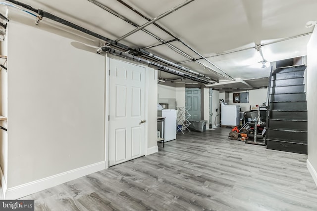 basement with light hardwood / wood-style floors and washer / clothes dryer