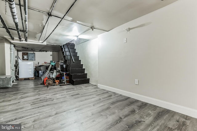 basement featuring electric panel and hardwood / wood-style flooring