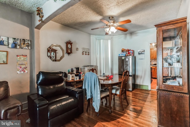 dining room with ceiling fan, wood-type flooring, and a textured ceiling