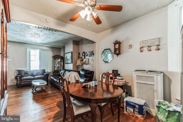 dining room featuring ceiling fan, dark wood-type flooring, and a textured ceiling