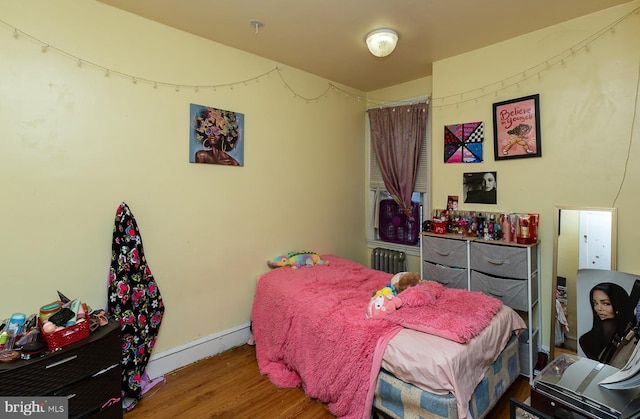 bedroom featuring wood-type flooring and radiator