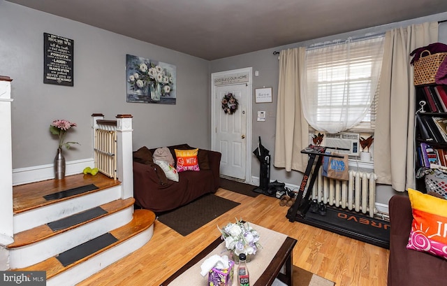 living room with wood-type flooring, radiator, and cooling unit