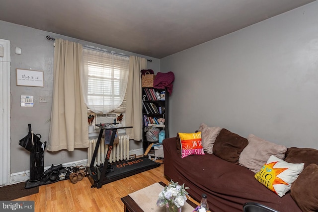 living room featuring radiator heating unit, cooling unit, and wood-type flooring