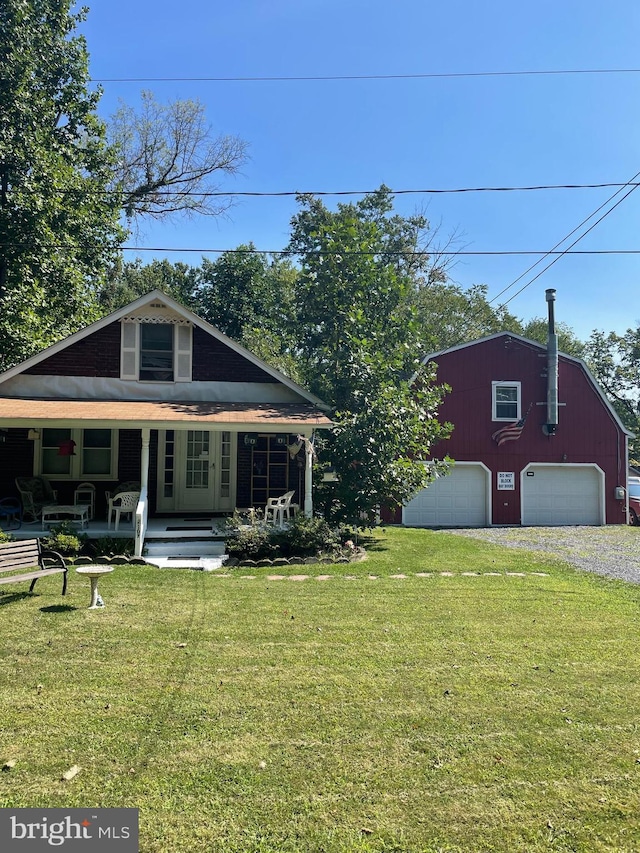 view of front of house featuring covered porch, a front yard, and a garage