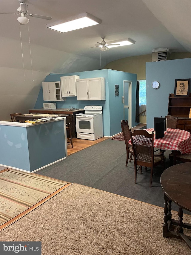 kitchen with white range with electric cooktop, lofted ceiling, ceiling fan, and white cabinetry