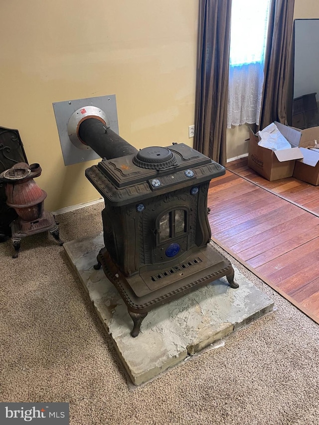 room details featuring hardwood / wood-style floors and a wood stove