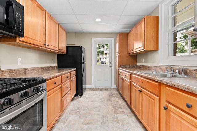 kitchen with sink, a paneled ceiling, and black appliances