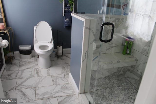 bathroom with toilet and a shower with shower door