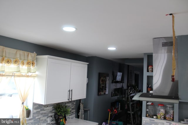 kitchen with decorative backsplash and white cabinets