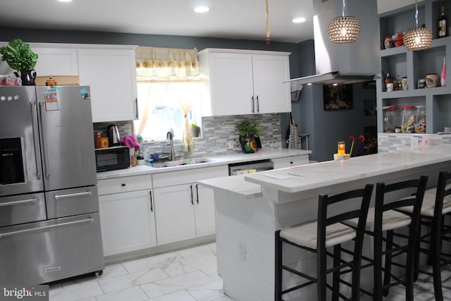 kitchen featuring a kitchen breakfast bar, sink, decorative backsplash, appliances with stainless steel finishes, and white cabinetry