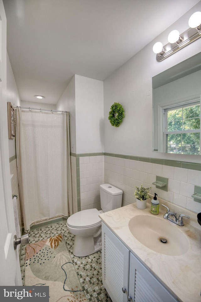 bathroom featuring tile walls, toilet, vanity, and tile patterned flooring