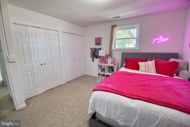 bedroom with two closets and carpet