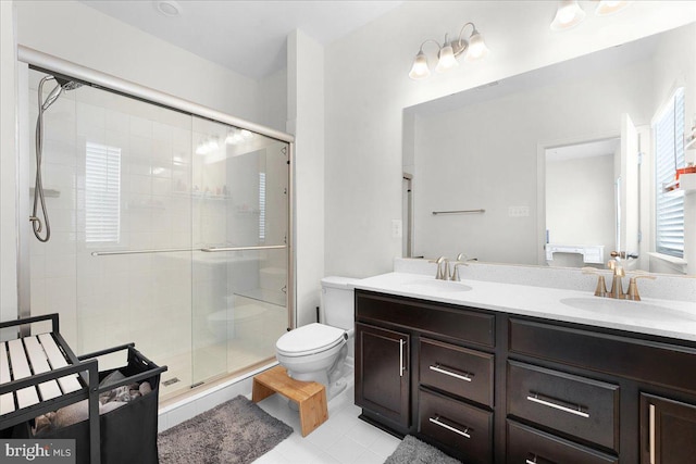 bathroom featuring tile patterned flooring, vanity, a shower with shower door, and toilet