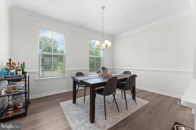 dining space featuring a chandelier, dark hardwood / wood-style floors, and crown molding