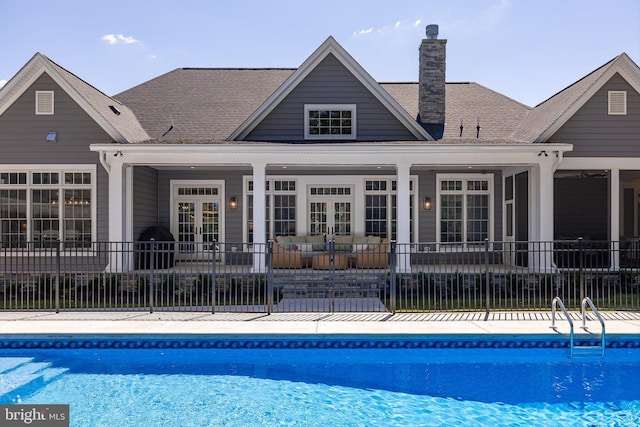 back of house with a fenced in pool and french doors