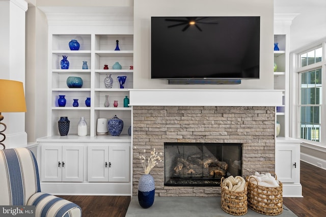 living room with dark hardwood / wood-style floors, built in features, and a brick fireplace