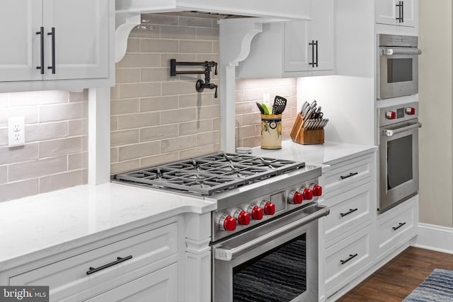 kitchen with decorative backsplash, light stone countertops, and stainless steel appliances