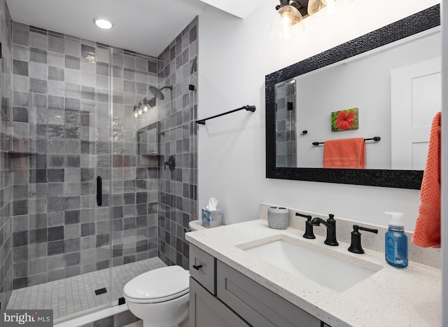 bathroom with an enclosed shower, vanity, and toilet