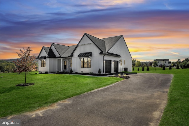 modern inspired farmhouse with a garage, central AC unit, and a lawn