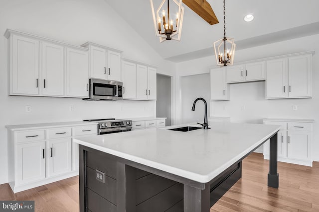 kitchen featuring sink, white cabinetry, stainless steel appliances, and a kitchen island with sink