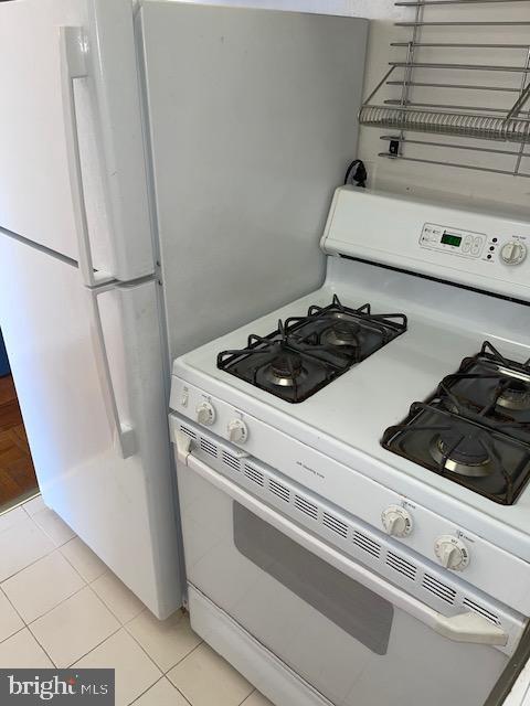 kitchen featuring white appliances and light tile patterned floors