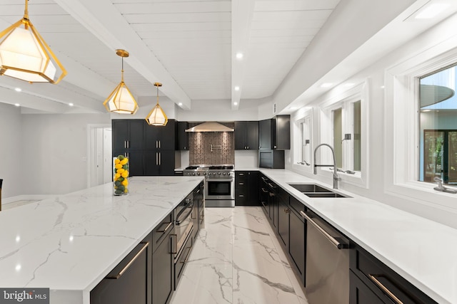 kitchen featuring tasteful backsplash, stainless steel appliances, wall chimney range hood, hanging light fixtures, and sink