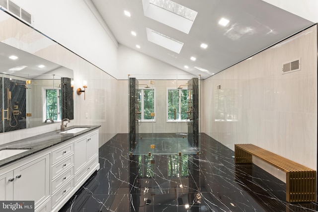 bathroom featuring tile floors, dual vanity, a skylight, and tile walls