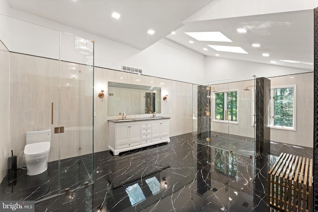 bathroom with an enclosed shower, tile walls, vaulted ceiling with skylight, vanity, and toilet