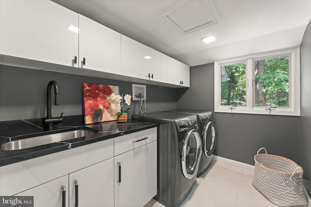 laundry area with cabinets, washer and clothes dryer, washer hookup, sink, and light tile floors