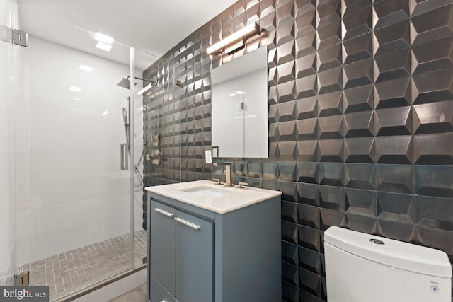 bathroom featuring walk in shower, tile walls, toilet, and vanity