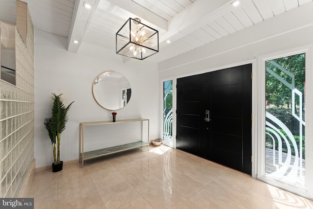 tiled entrance foyer with a chandelier and beam ceiling