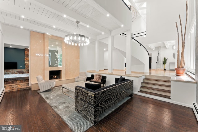 living room with a baseboard radiator, a fireplace, beam ceiling, dark wood-type flooring, and a high ceiling