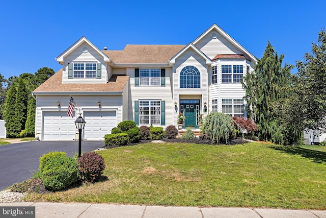 view of front of home with a garage and a front yard