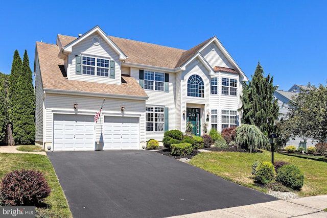 view of front facade with a garage and a front lawn