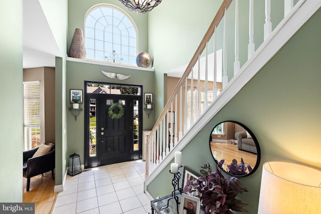 foyer entrance featuring light hardwood / wood-style flooring and a towering ceiling