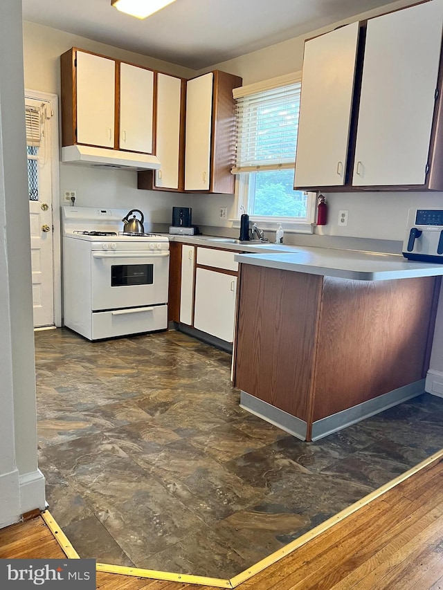 kitchen featuring white range with gas stovetop, custom range hood, dark hardwood / wood-style flooring, sink, and white cabinetry