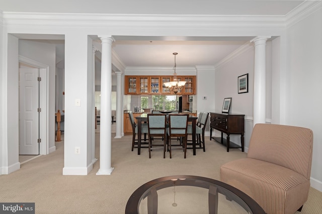 carpeted dining room featuring ornate columns, crown molding, and a notable chandelier