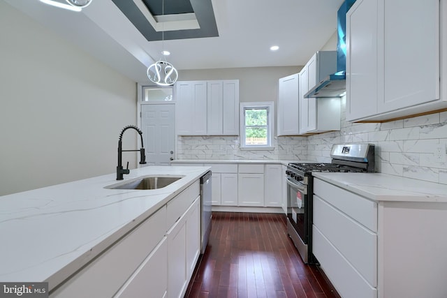 kitchen with light stone countertops, sink, pendant lighting, white cabinets, and appliances with stainless steel finishes