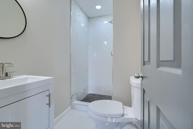 bathroom featuring vanity, toilet, and a tile shower