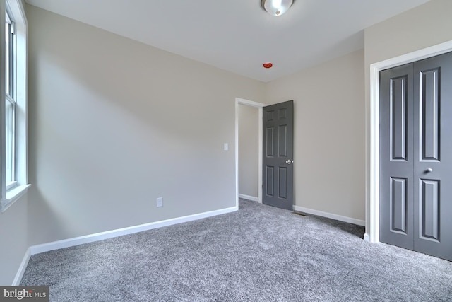 unfurnished bedroom with carpet flooring and a closet