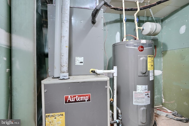 utility room with heating unit and electric water heater