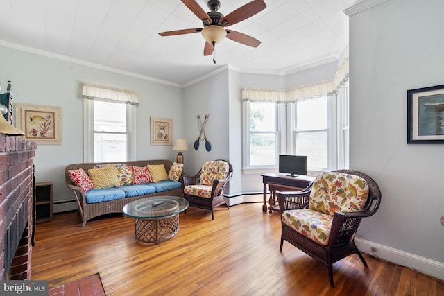 living room with ceiling fan, a baseboard radiator, a brick fireplace, crown molding, and hardwood / wood-style floors