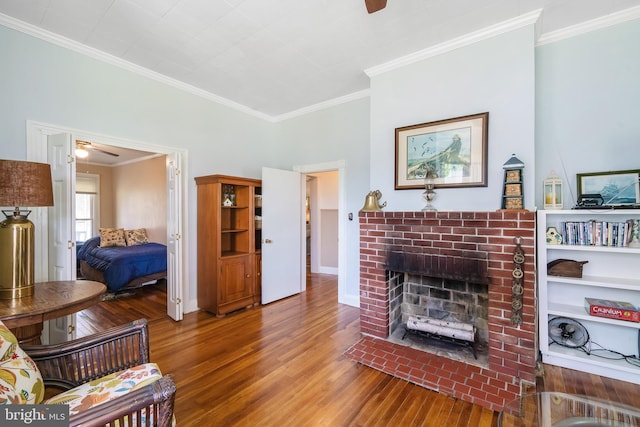 living room featuring a fireplace, ceiling fan, wood-type flooring, and crown molding