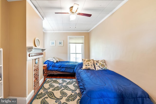 bedroom featuring ceiling fan, wood-type flooring, and ornamental molding