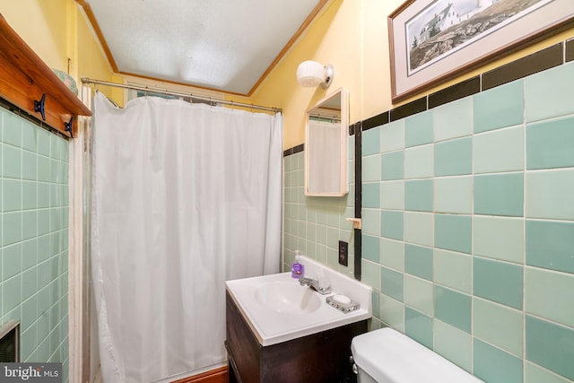 bathroom featuring vanity, toilet, tile walls, and ornamental molding