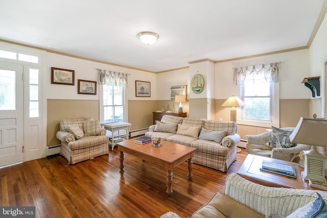 living room with a healthy amount of sunlight, ornamental molding, baseboard heating, and dark wood-type flooring